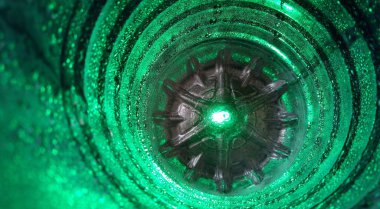 Yüzeyi parlak su damlacıklarıyla kaplı plastik bir şişenin içindeki soyut ve kozmik fotoğraf.