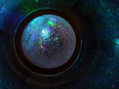 Yaratıcı makro fotoğrafçılıkta küçük su damlalarına yansıyan koyu mavi ışık