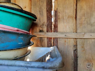 Tahtalardan ahşap çitler ve farklı renklerde eski havzalar.