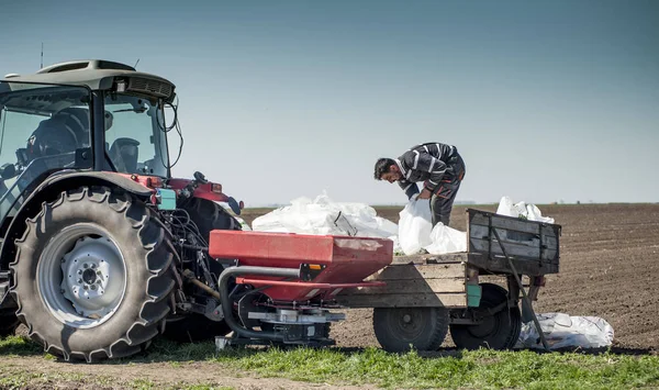 Tractor spreading artificial fertilizers in field — Stock Photo, Image