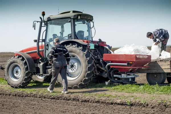 Trator espalhando fertilizantes artificiais no campo — Fotografia de Stock