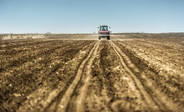 Tractor spreading artificial fertilizers in field — Stock Photo, Image