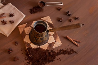 Türkçe kahve ve taze demlenmiş kahve anason ve tarçın çubuklu ahşap saplı kahverengi arka plan manzaralı bir branda torbasıyla düz yatıyordu.