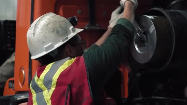 机械师更换了卡车上的过滤器 他戴着头盔 反光背心 眼镜和手套 这是为了安全起见 — 图库视频影像