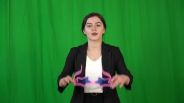 Güzel bir kız yıldız şeklinde gözlük takar. Arkaplan anahtarlama için yeşil bir ekrandır.