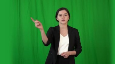 Takım elbiseli güzel esmer kız sanal panelle çalışıyor. Arkaplan - anahtarlama için yeşil ekran.