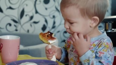 Sevimli bebek peynirli krep yiyor. Evindeymiş. Kahvaltı yapıyor..