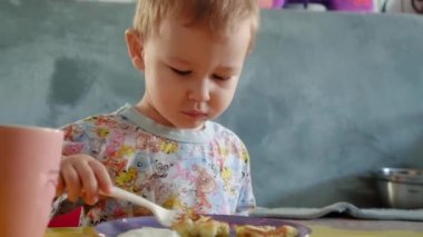 Sevimli bebek peynirli krep yiyor. Evindeymiş. Kahvaltı yapıyor..