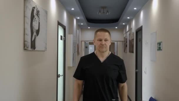 Tıbbi Önlüklü Bir Doktor Koridorda Yürür Yüz Koruması Bandajı Takar — Stok video