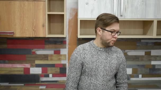 Mężczyzna Brodzie Okularach Ubrany Dżinsy Sweter Stoi Kuchni Patrzy Lewo — Wideo stockowe