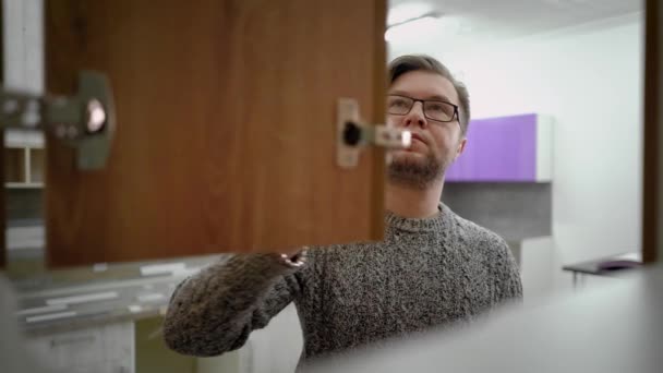 Egy Szakállas Szemüveges Férfi Pulóvert Visel Konyhában Áll Kinyitja Polcot — Stock videók
