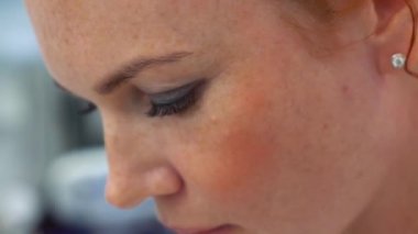 Kızıl saçlı bir masöz güzel bir genç kızın kafasına masaj yapıyor..