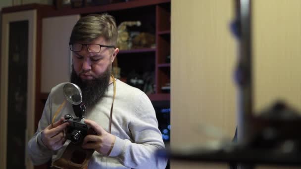 Genç Sakallı Adam Klasik Bir Kamera Kullanıyor Eski Fotoğraflara Bakıyorum — Stok video