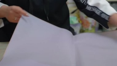 Bir çiçekçi bir buket mor lale için ambalaj kağıdı hazırlar..