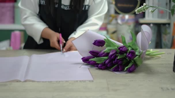 Florista Recoge Ramo Tulipanes Morados Chica Corta Envoltorio Regalo Para — Vídeo de stock