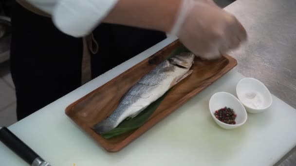 Szef Kuchni Brudzi Paprykuje Rybę Leży Stole Kuchennym Obok Przyprawy — Wideo stockowe