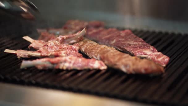 요리사는 맛있는 스테이크를 요리한다 클로즈업 요리는 요리용 통구이로 고기를 뒤집는다 — 비디오