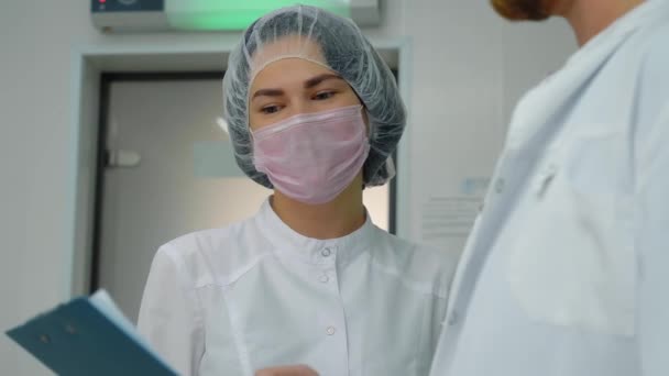 Ein Junger Arzt Arztkittel Diskutiert Mit Einer Schönen Krankenschwester Über — Stockvideo