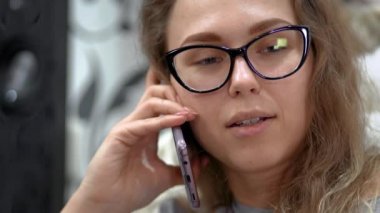 Kız evde dizüstü bilgisayarı için çalışıyor. Cep telefonuyla konuşuyor.. 