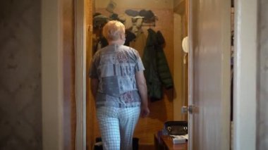 Büyükannem kapı deliğinden bakıyor. COVID-19 koronavirüs salgını sırasında gönüllüler bekliyor..