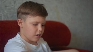 Büyükbaba torunuyla konuşur ve bir kitap okur. Torunu oyuncak tankının uzaktan kumandasını tutuyor..