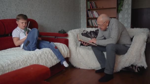 Opa Spricht Mit Seinem Enkel Und Liest Ein Buch Der — Stockvideo