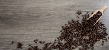 Kavrulmuş kahve çekirdekleri ahşap bir zemin