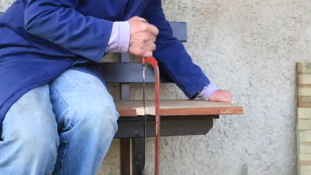 Dłonie Starszego Mężczyzny Pracującego Zewnątrz Pikniku Desce Cięcia Piłą Ręczną — Wideo stockowe