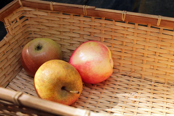 Hasır piknik sepetinde elmalar.