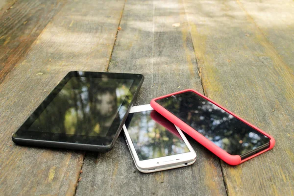 Gadget 'lar - telefon, akıllı telefon, tablet ahşap bir masanın üzerinde..