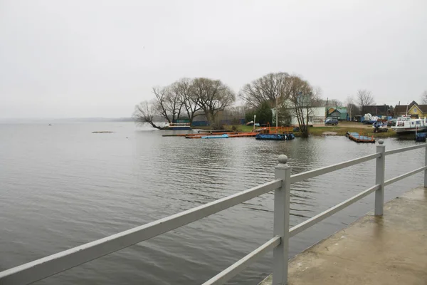 Gölün seddi. Sahilde çit ve ağaçlar.