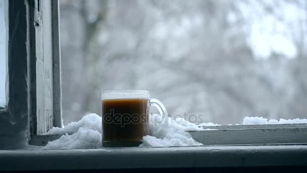 Hot cup of coffee on window winter — Stock Video