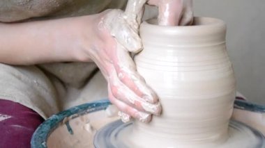 Kadın bir sürahi beyaz kil şekil oluşturur