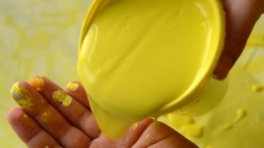 Adam ellerinde kalın boya dökülen ve beyaz yüzeyinde losyonları