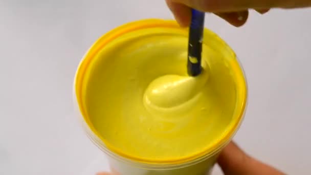 Mélange de peinture jaune sur fond blanc gros plan — Video