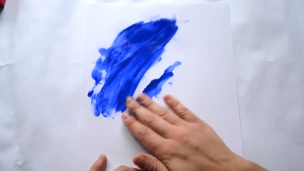 Kız el boya mavi boya beyaz kağıt üzerinde — Stok video