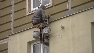 Adam kaplama, evi sıvama yüksek katlı inşaat üstünde çalışıyor