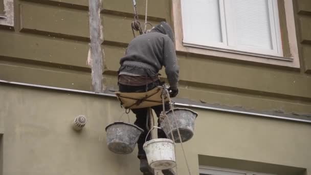 Mannen arbetar på höghus fungerar beklädnad, puts av huset — Stockvideo