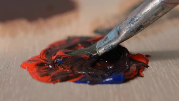 Mélange de la peinture à l'huile bleue et rouge dans la palette — Video