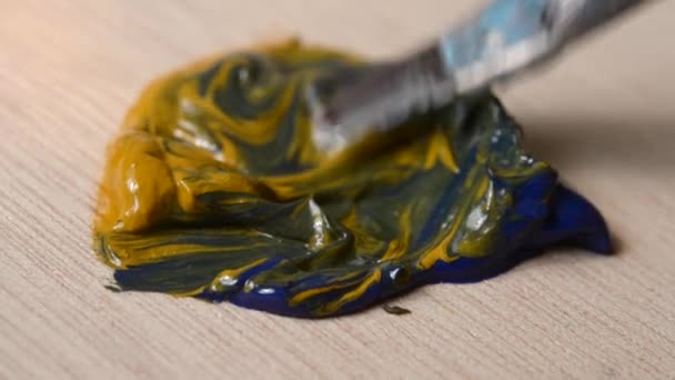 Pintura Amarillo y azul se mezclan con un pincel — Vídeos de Stock