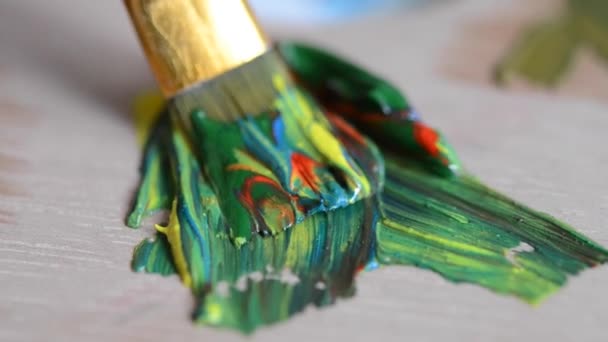 Смешивание желтой и зеленой масляной краски с красной и синей в палитре — стоковое видео
