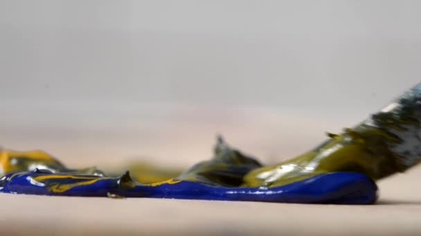 Змішування олійної фарби жовтого і синього кольору в палітрі — стокове відео