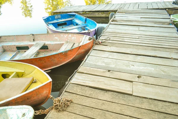 Hölzerne alte Anlegestelle und die Nasen der Boote — Stockfoto