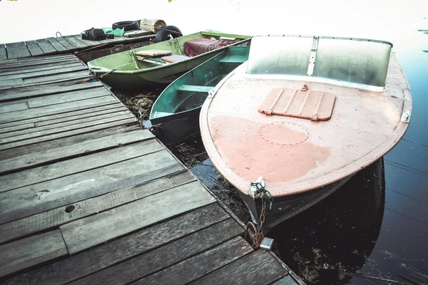 Катер и обычные лодки на пирсе — стоковое фото