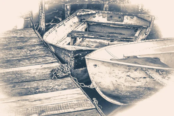 Старое винтажное фото. Несколько старых простых лодок на пирсе — стоковое фото
