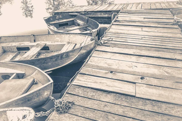 Old vintage photo. A few old simple boats on the pier — Stock Photo, Image