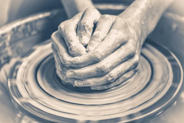 Old vintage photo. Master potter folded together hands sculpts a clay product — Stock Photo, Image
