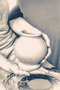 Potter yapılmış tencere tutar. Eski vintage tarzı.