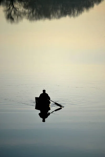 Рибалка на річці з дзеркальним відображенням води — стокове фото