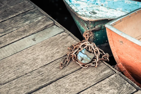 Velho ferro desgastado e narizes barco gasto amarrado a doca de madeira — Fotografia de Stock